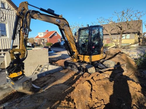 grävmaskin Grävmaskin i trädgård.